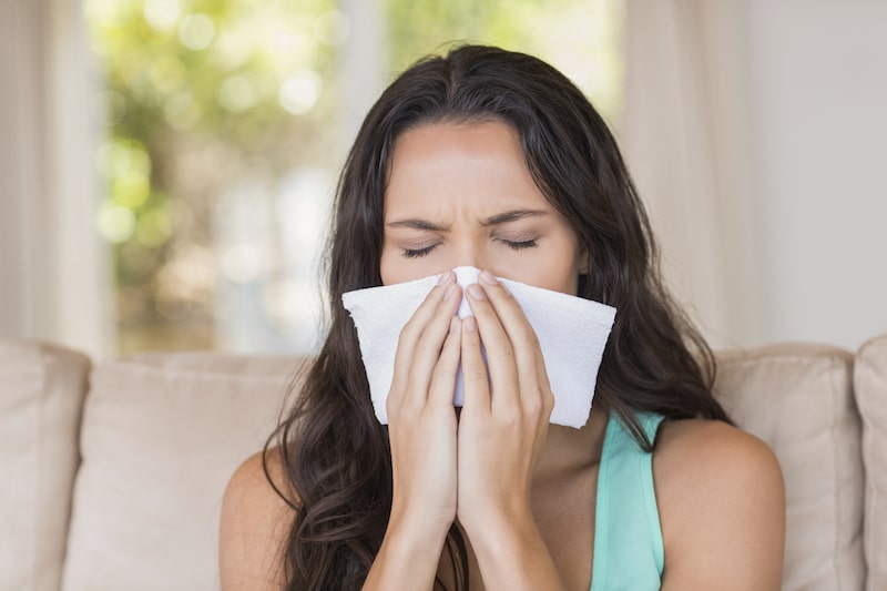 Women sneezing into a tissue