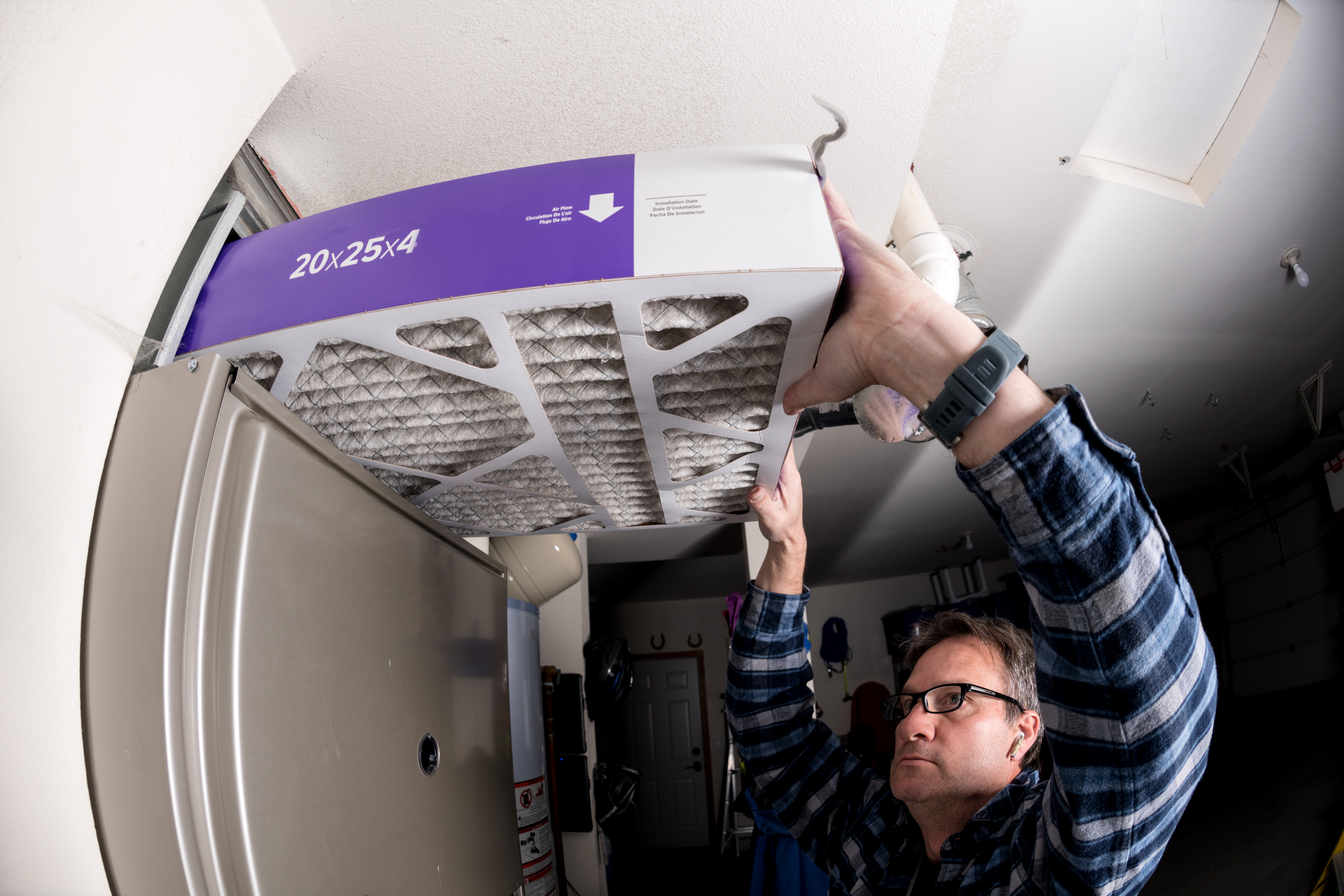Handyman replaces the filter in the hot air furnace at a home Technician replaces furnace filter